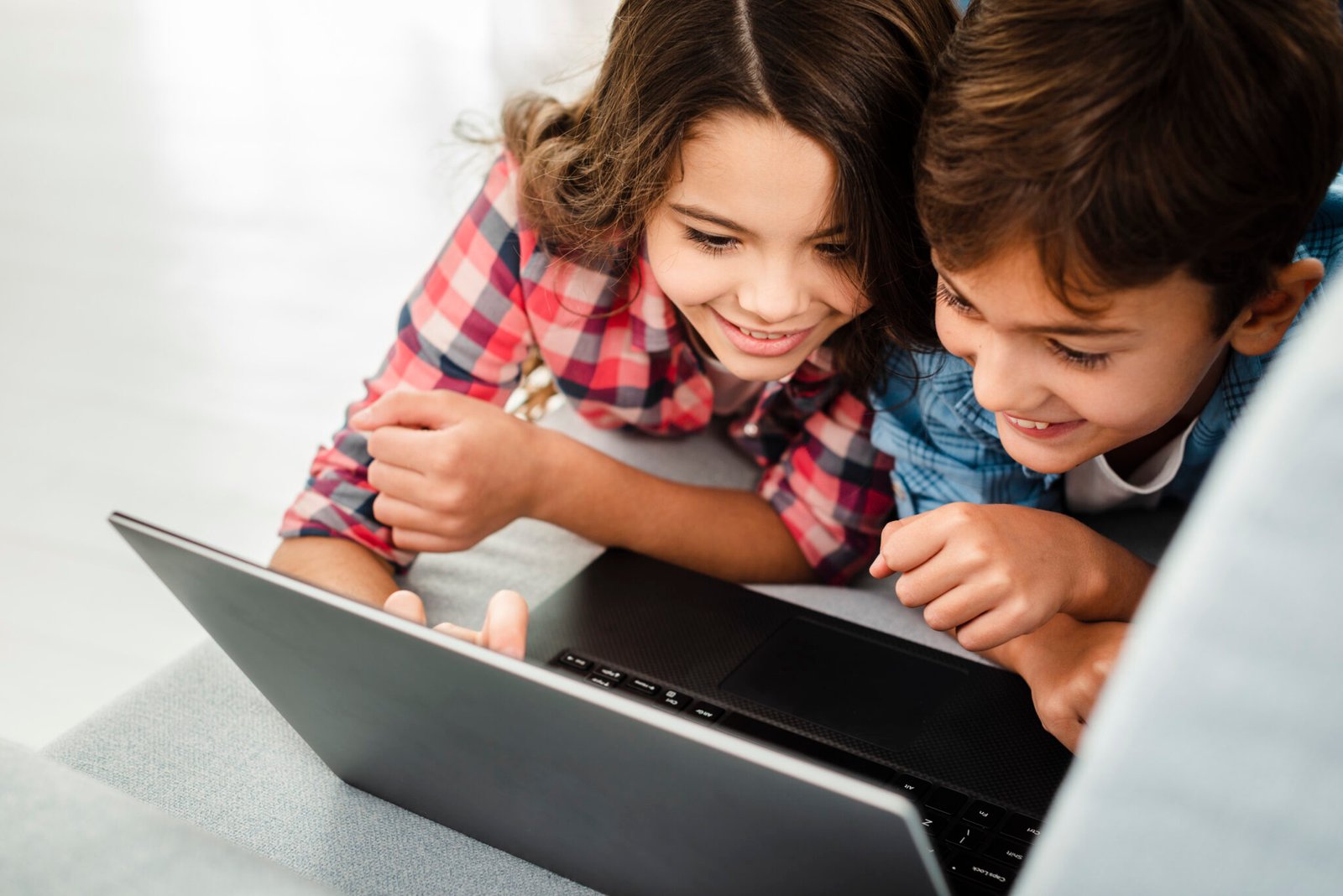 hermanos-de-alto-angulo-en-casa-usando-una-computadora-portatil